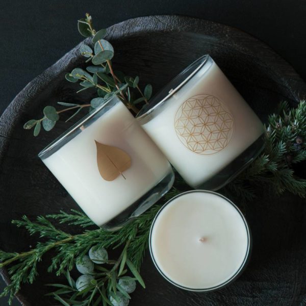 3 white Signature Scented Candles, two on side, one upright