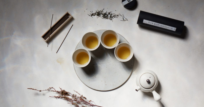 overhead shot four tea cups, teapot and incense